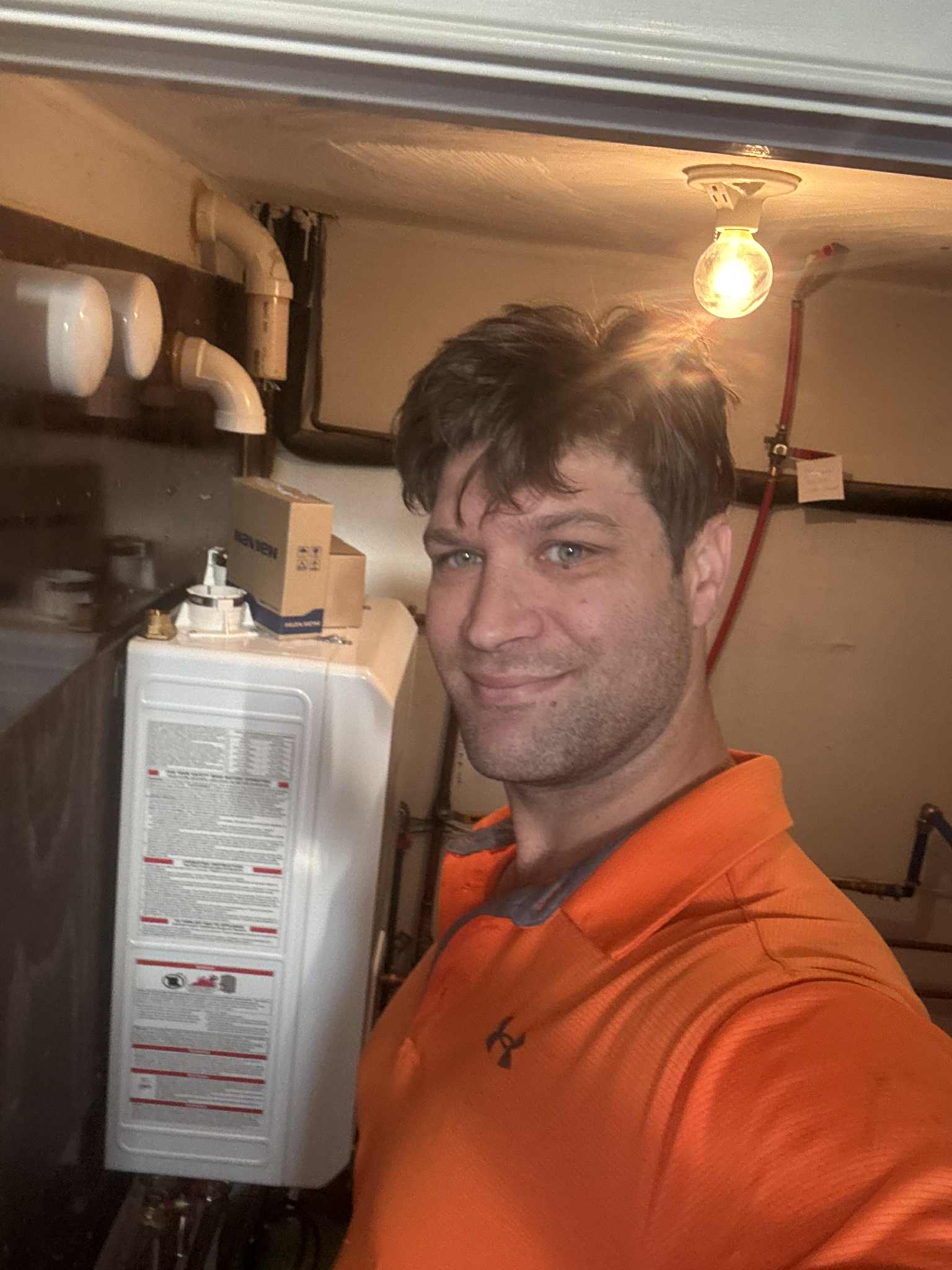 Nick Johnson working beside a residential water heater